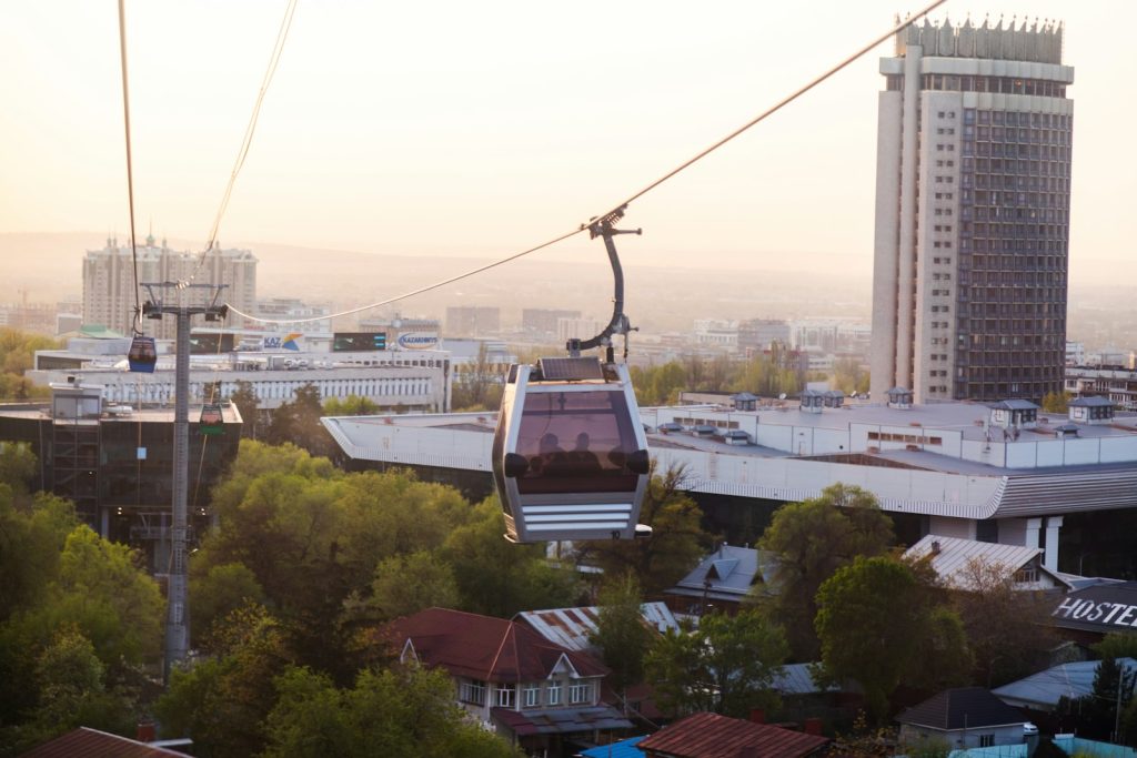 A gondola cabin crossing above a city at dusk